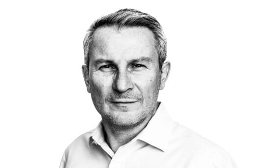 Headshot of a man in white shirt looking at the camera in front of a white background by portrait photographer Andy Barnham