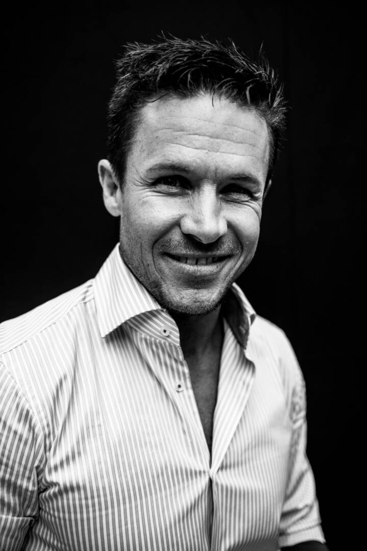 Lifestyle portrait of smiling Austrian skydiver and daredevil Felix Baumgartner wearing striped shirt by portrait photographer Andy Barnham