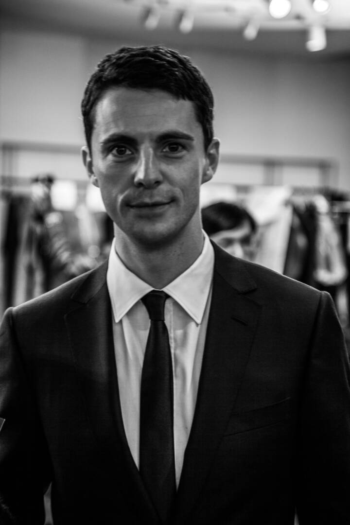 Lifestyle portrait of English actor Matthew Goode in suit and tie backstage at a fashion show by portrait photographer Andy Barnham
