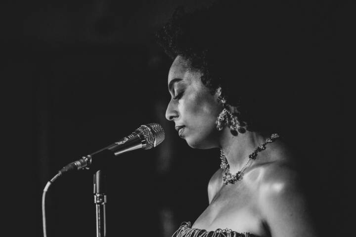 Lifestyle portrait of Celeste, American-British singer and songwriter standing next to a microphone by portrait photographer Andy Barnham