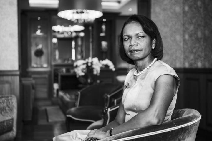 Lifestyle portrait of former United States Secretary of State Condoleezza Rice with pearl necklace sitting in opulent drawing room by portrait photographer Andy Barnham