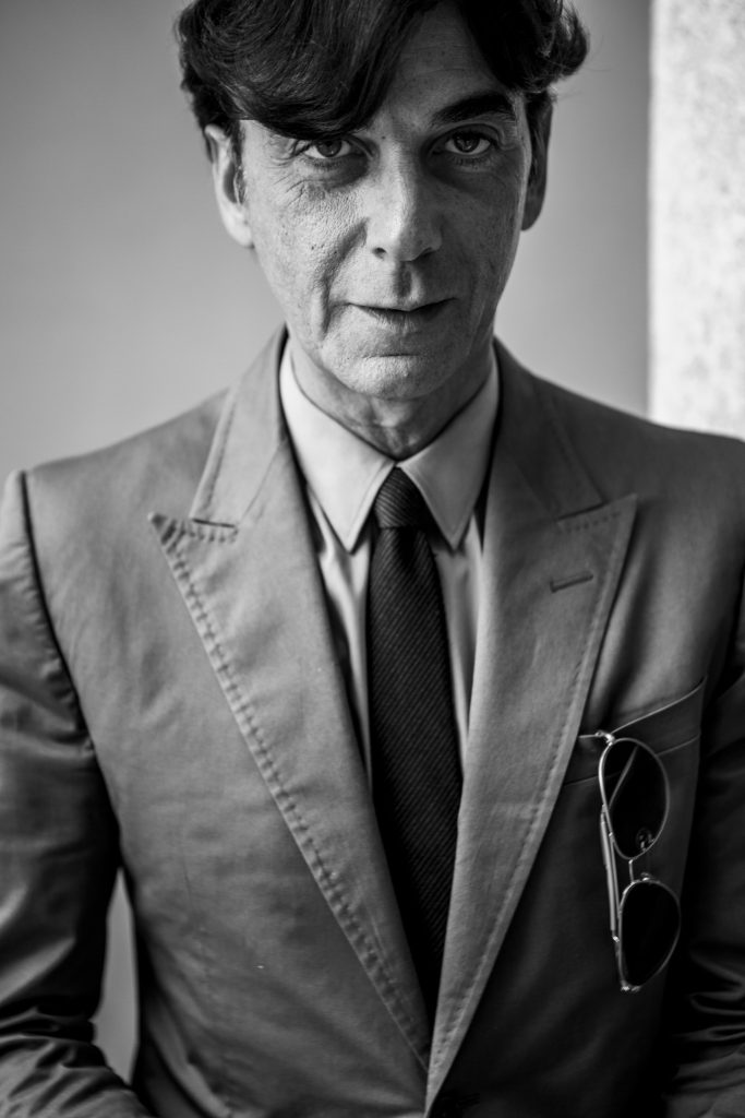 Black and white portrait of former CEO Gucci Patrizio di Marco in a suit with sunglasses in his breast pocket looking at the camera by portrait photographer Andy Barnham
