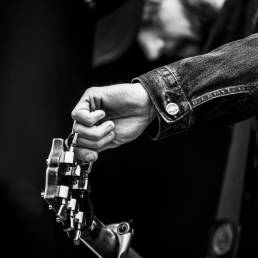Music photography of close up of Ben Bridwell, lead singer of the American rock band Band of Horses, tuning his guitar by portrait photographer Andy Barnham