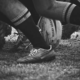 Black and white photograph of a rugby ball at the base of a scrum
