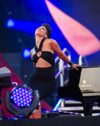 Music photography of Alicia Keys on stage next to a grand piano at the Global Citizen Festival in NYC by photographer Andy Barnham
