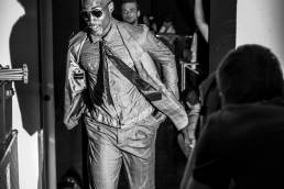 Backstage at Emporio Armani, designed by Giorgio Armani, a male model runs into the backstage area in order to change looks during a fashion show by Andy Barnham