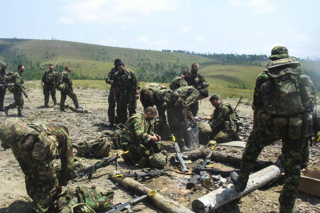 British Army soldiers stopping too refill their canteens in open ground in the Belize jungle