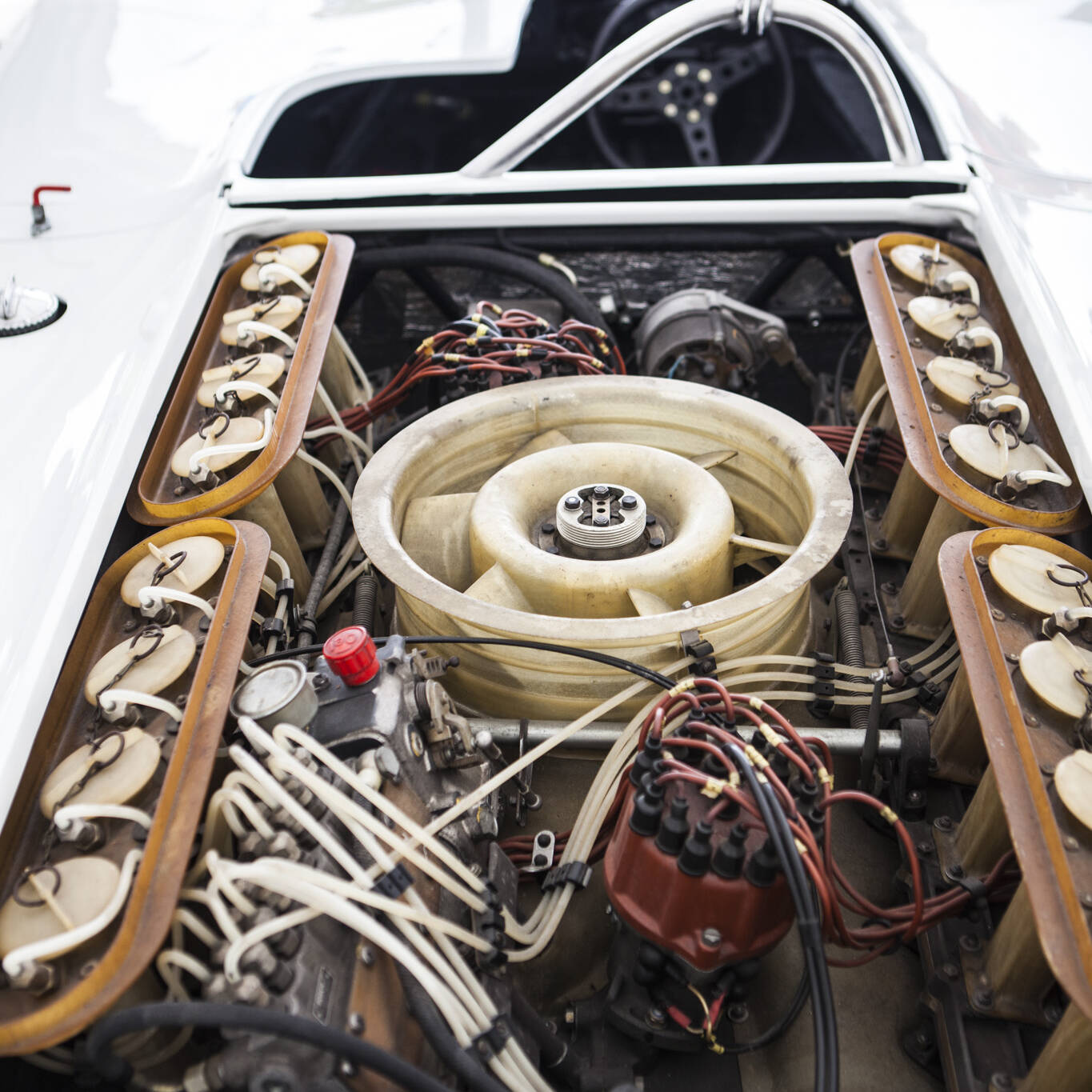 Detail of sixteen-cylinder piston engine behind the driving seat of a classic white sports car