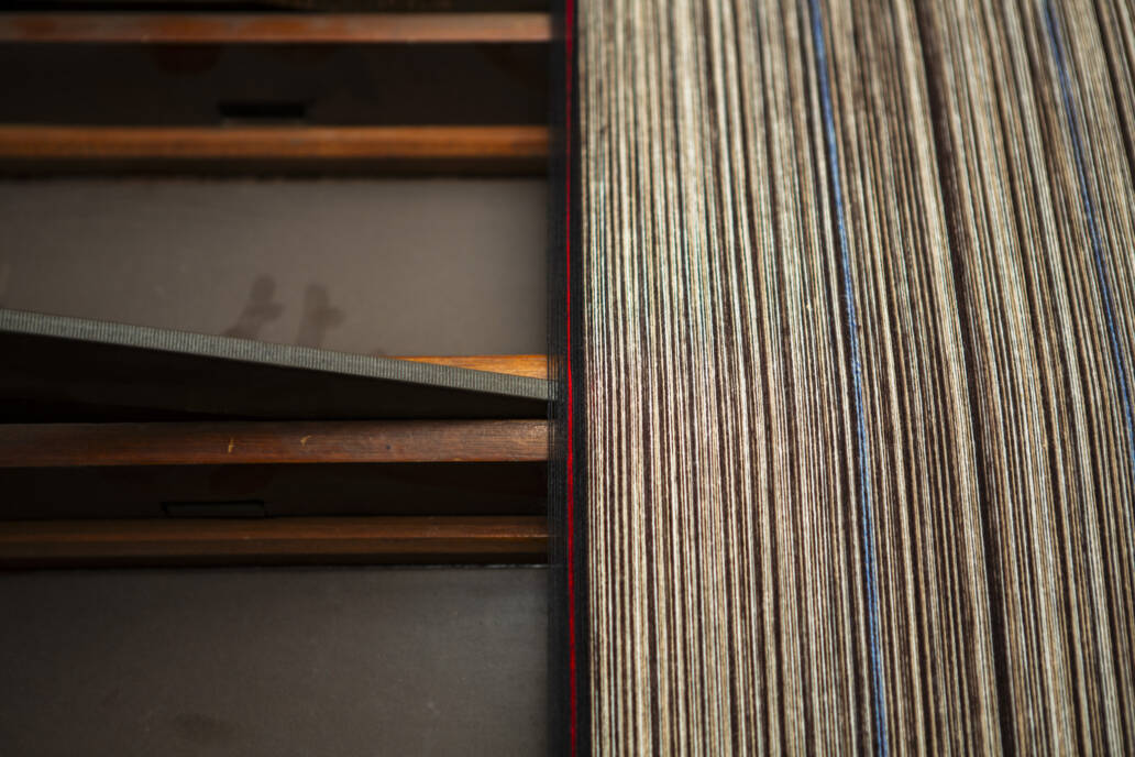 Thread being woven into a pattern on a loom