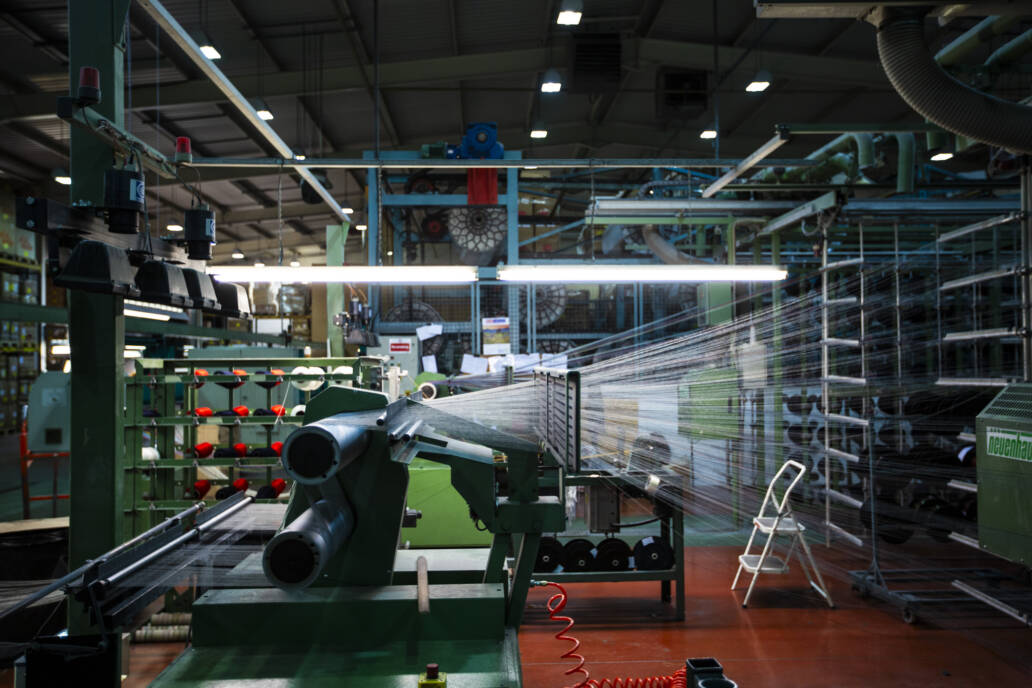 Spiderweb of threads in a fabric mill attached to a loom