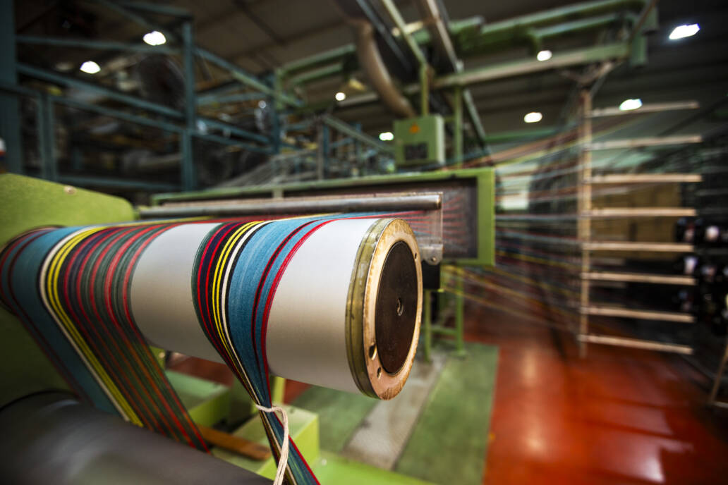Colourful threads in a fabric mill attached to a loom
