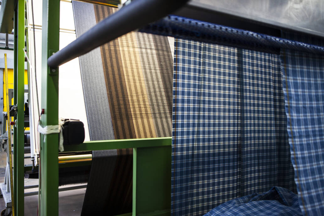 Newly woven fabric rolling off the end of a loom