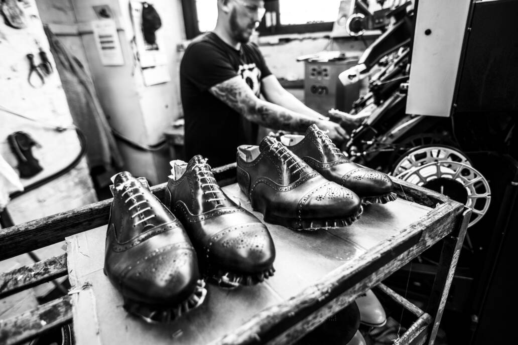 Two pairs of shoe uppers shaped over lasts prior to being soled in a shoe factory
