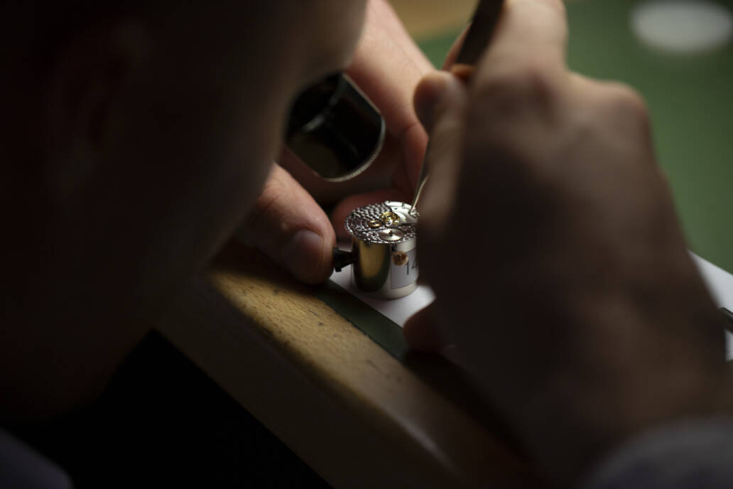 Man with loupe fixing a watch movement