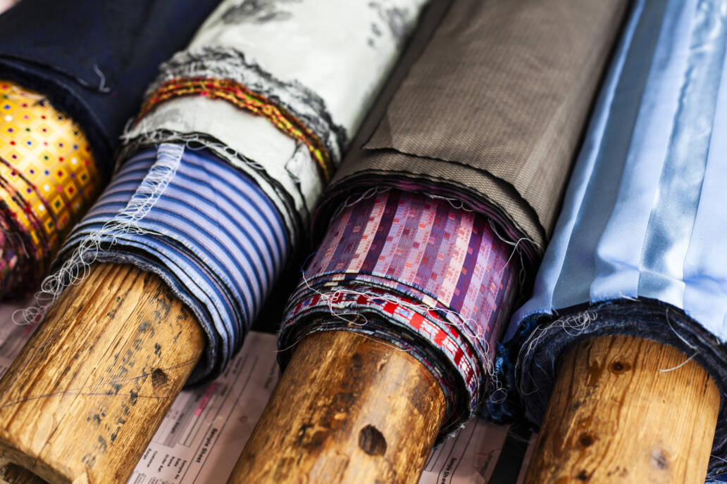 Wooden bolts of cloth with different patterns of material wrapped around them