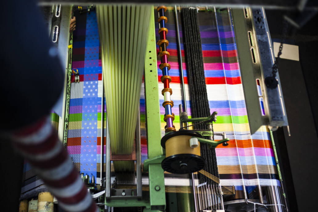 Loom weaving colourful threads into a pattern