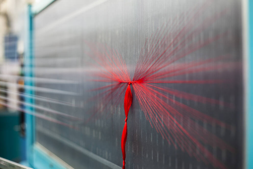 Spiderweb of red thread in a fabric mill